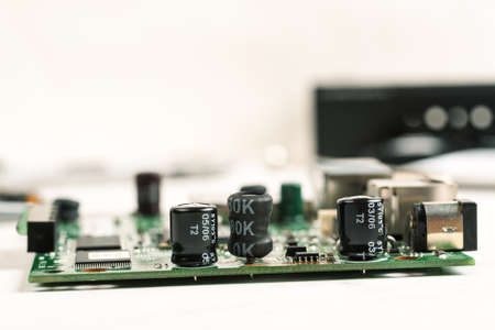 Disassembled electronic gadget with visible parts on a white tableの写真素材