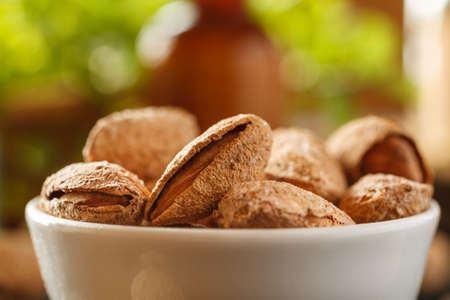 Almond in shell in a white bowl, macro shot