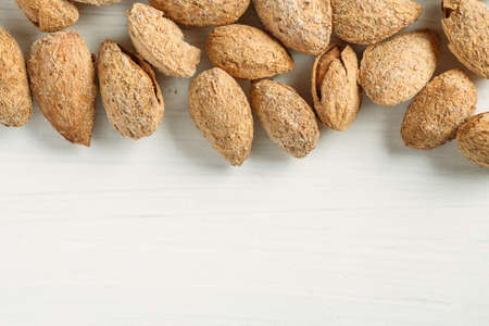 Almond in shell on a white table, top view, copy spaceの写真素材