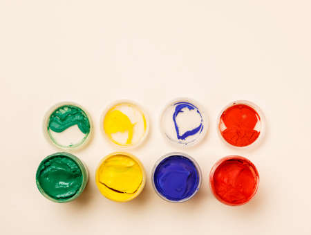 Open small paint jars on a table, selective focus, top viewの写真素材