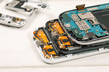 Disassembled cell phones and other gadgets in repair shop