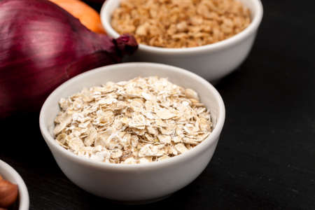 Cereals in a white ceramic dishes with different vegetables closeup shot