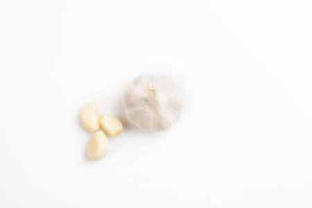 Fresh peeled and unpeeled garlic on a white backgroundの写真素材