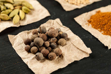 Allspice on a piece of paper among other spices