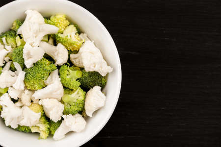 Fresh salad with raw broccoli and cauliflower in a white dishの写真素材
