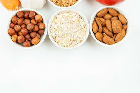 Nuts and cereals in a white ceramic dishes with vegetablesの写真素材