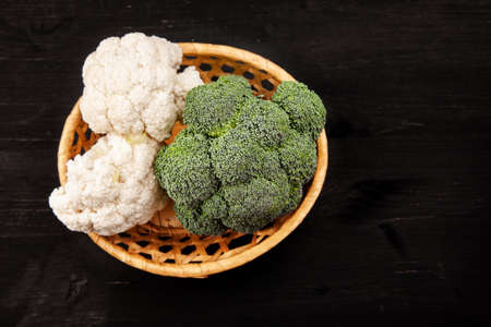 Green fresh broccoli with cauliflower on a dark wooden tableの写真素材