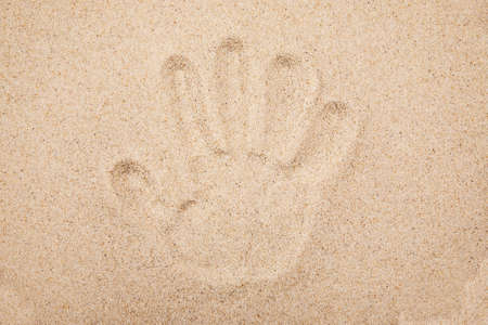 Imprint of the human hand in the sandの写真素材
