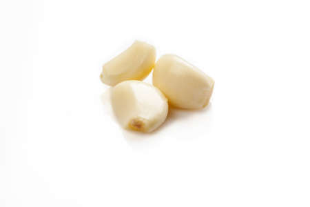 Three pieces of peeled garlic on a white backgroundの写真素材