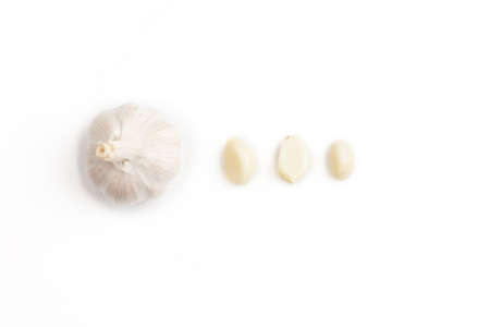 Fresh peeled and unpeeled garlic on a white backgroundの写真素材