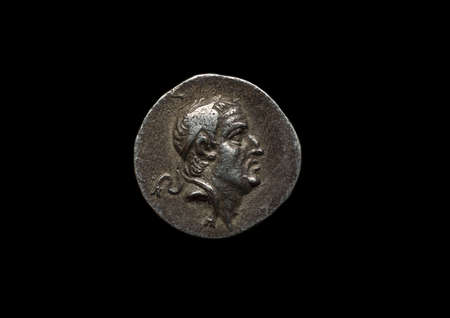 Ancient silver coin isolated on blackの写真素材