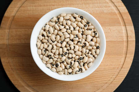 White kidney beans in a bowl on a wooden table, top viewの写真素材