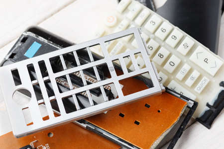 Parts of broken tv remote control on a white table, closeupの写真素材