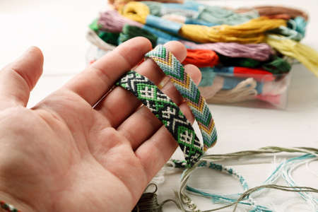 Hand holding different woven friendship bracelet, closeup shot