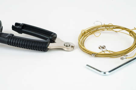 Tools for acoustic guitar strings change on a white backgroundの写真素材
