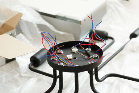 Chandelier with wires and tools on the floor, preparation to installation