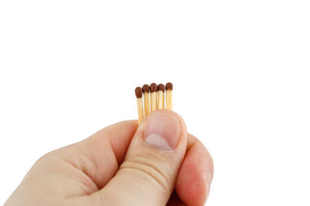 Hand holding five matches on a white background