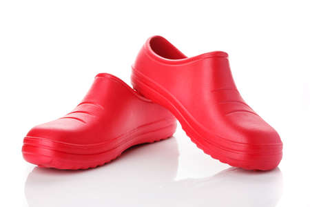 Pair of red rubber shoes on a white background