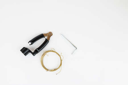Tools for acoustic guitar strings change on a white background, top view