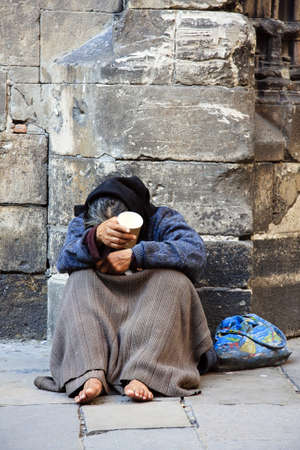 A homeless man holds cup asking for some change. のeditorial素材