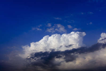 White cloud on blue sky with dark clound in frontの写真素材