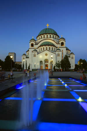 St Sava temple with public lights on and the fountain with water and blue lights in front.