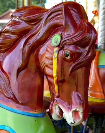 The head of a deep maroon carousel horse on a festival merry-go-roundの写真素材