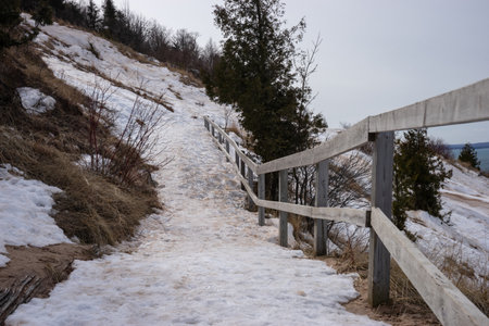 Wooden fence on the top of a hill in winter with snowの写真素材