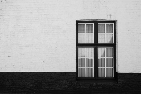 White brick wall with window. Black and white image. Copy space.の写真素材
