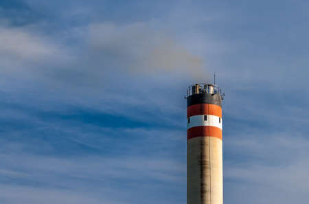 Industrial smokestack pollution with blue and cloudy sky