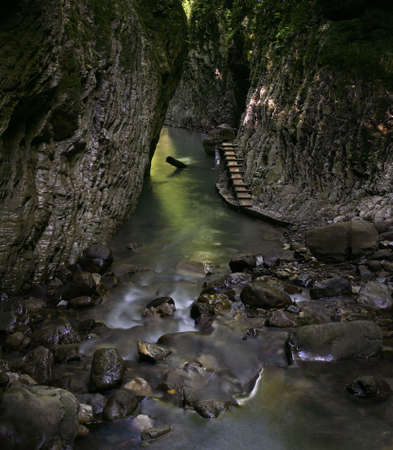 The river has spread between stones and rocksの写真素材