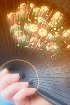 Romantic photo of female hand holding a fanの写真素材