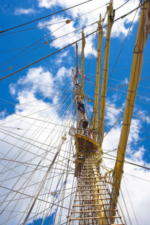A telephoto of sailors at an old, tall sailing boatの写真素材