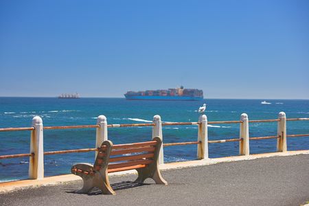 A photo of a lonely bench by the oceanの写真素材