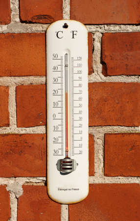 A photo an outdoor thermometer on brick wallの写真素材