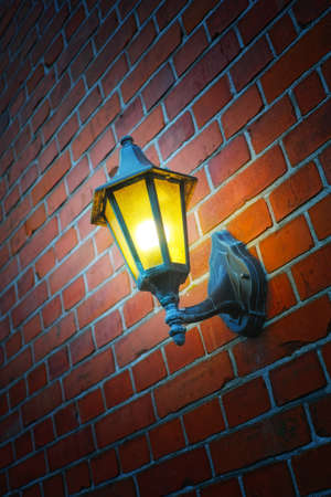 a photo of an outdoor lamp on a brick wallの写真素材