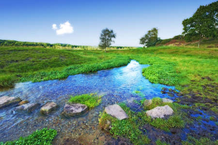 A photo of a small creek and lakeの写真素材