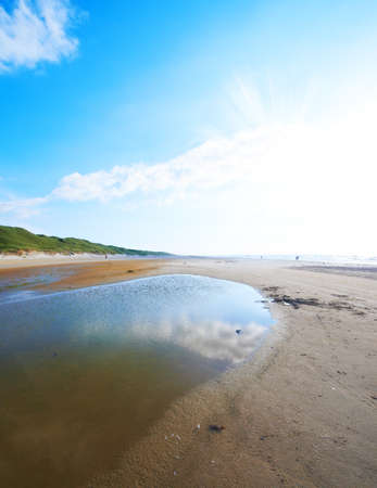 A photo a small creek running out in the ocean, Jutland, Denmarkの写真素材