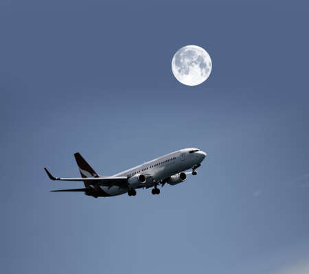 Airplane in the night sky and moonのeditorial素材
