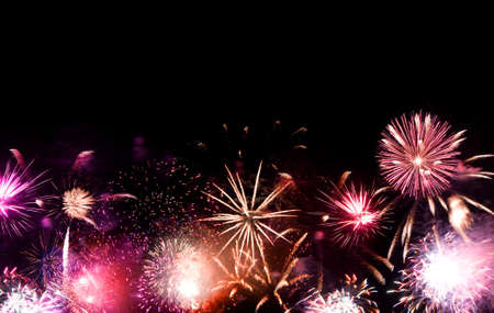 Beautiful fireworks going off with plenty of negative space in the dark night sky.の写真素材