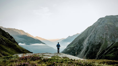 Hiker on the top of a mountain looking at the beautiful landscapeの写真素材