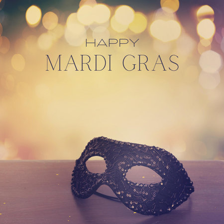 Mardi Gras mask on wooden table with bokeh backgroundの写真素材