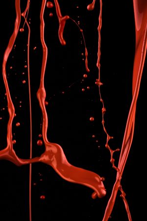 Splashes of red paint. Isolated paint on black in a movement.