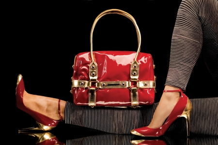 Red shoes and bag. View of woman's legs wearing red shoes with red bag.の写真素材