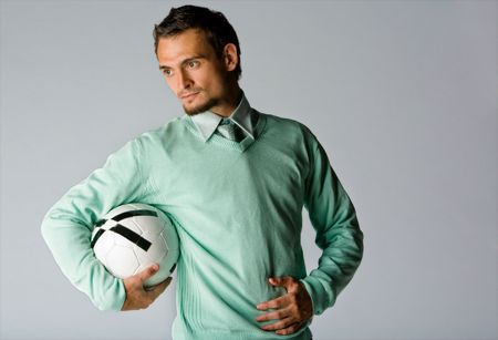 Man Holding Soccer Ball. Business professional wearing a tie and sweater holds a soccer ballの写真素材