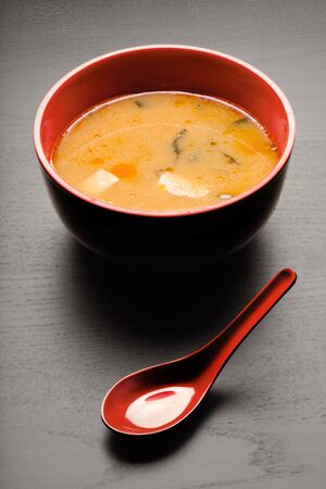 A close-up of a spoon and a soup plate with delicious miso soup.の写真素材