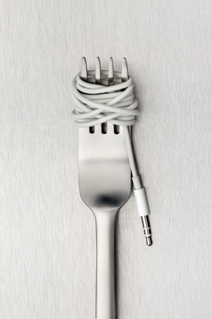 Food for new generation - A shining fork with noodle made of cable with music jack plug in metal background の写真素材