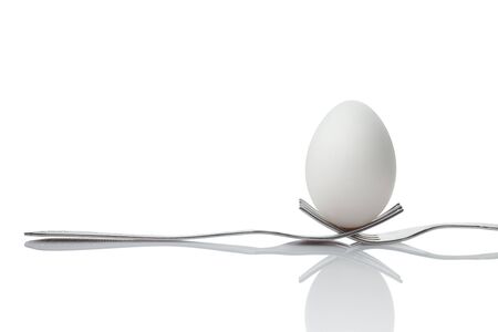 Hold the world in your hands - An egg hanging by two forks の写真素材