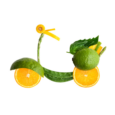 A food concept of a retro scooter Vespa made of fruits and vegs isolated on white.の写真素材