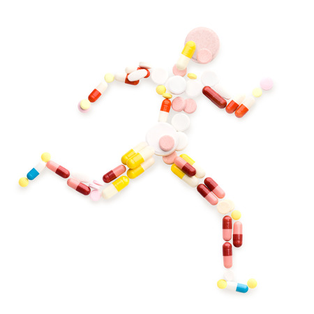 Doping drugs and pills in the shape of an athletic runner on track の写真素材